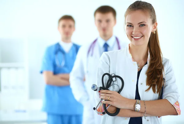 Attractive female doctor in front of medical group — Stock Photo, Image