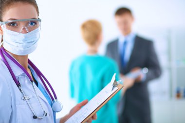 Kadın doktor hastanede dosyayla bekliyor. 