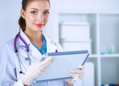 Kadın doktor hastanede dosyayla bekliyor. 