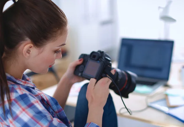 Kobieta fotograf siedzi na biurku z laptopem — Zdjęcie stockowe