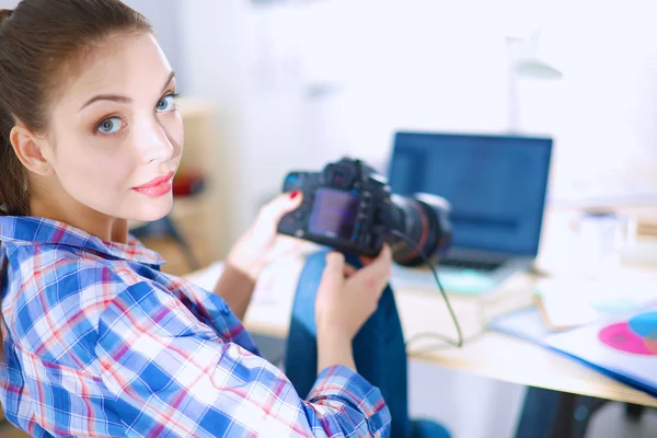 Vrouwelijke fotograaf zittend op het bureau met laptop — Stockfoto