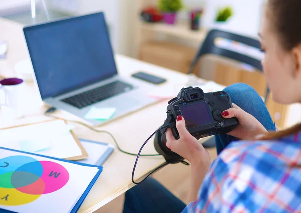 Vrouwelijke fotograaf zittend op het bureau met laptop — Stockfoto