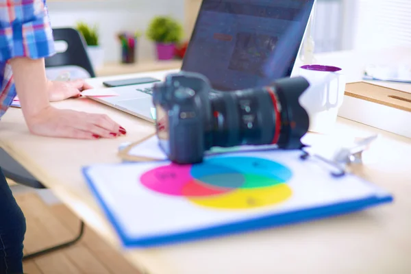 Female photographer sitting on the desk with laptop — Stock Photo, Image