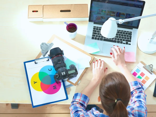 Vrouwelijke fotograaf zittend op het bureau met laptop — Stockfoto