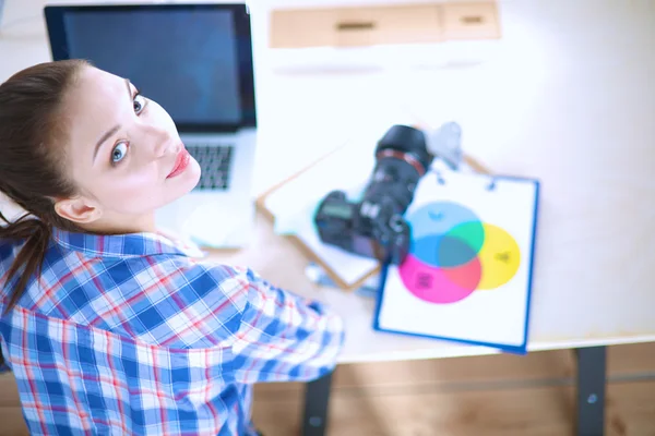 Kvinnlig fotograf sitter på skrivbordet med bärbar dator — Stockfoto