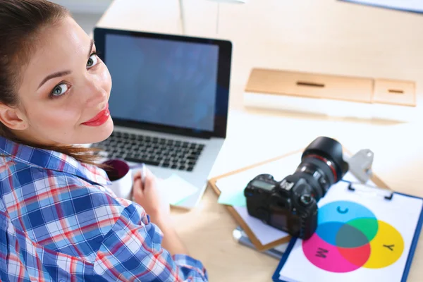 女摄影师带着笔记本电脑坐在桌子上 — 图库照片
