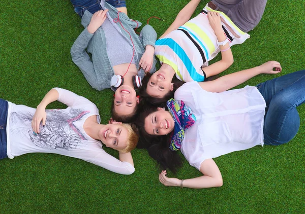 Quatre jeunes femmes allongées sur l'herbe verte — Photo