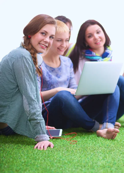 Gruppe junger Studenten sitzt auf grünem Gras — Stockfoto