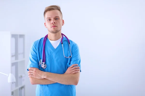 Médico con estetoscopio de pie, brazos cruzados, aislado sobre fondo blanco — Foto de Stock