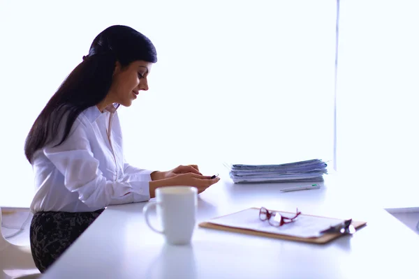 机の上に座っている書類を持つ女性 — ストック写真