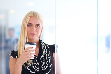 Ofiste kahve içen genç bir kadın.