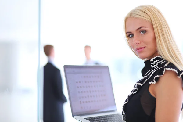 Business kvinna står med sin personal i bakgrunden på moderna ljusa kontorsrum konferens — Stockfoto