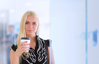 Ofiste bir fincan kahve ayakta tutan işkadını