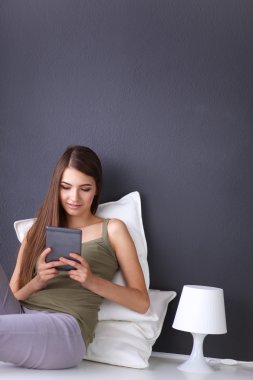 bir yastık ve uçak tablo ile katta oturan güzel esmer kadın