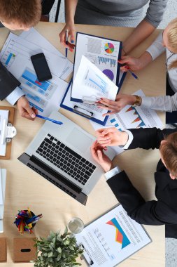 İş adamları iş toplantısında, ofiste oturup tartışıyorlar.