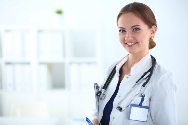 Kadın doktor hastanede steteskopla dikiliyor. 