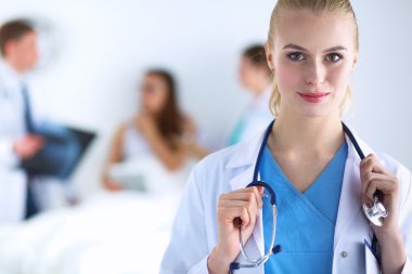 Kadın doktor hastanede steteskopla dikiliyor. 