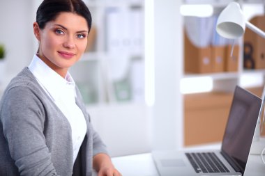 Ofiste masa başında oturan çekici bir iş kadını.