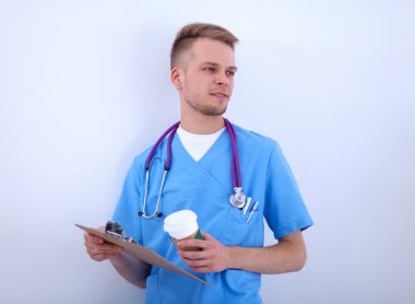 Steteskoplu doktor ayakta, çapraz kollu, beyaz arka planda izole.