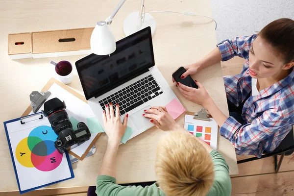 Femme photographe assise sur le bureau avec ordinateur portable — Photo