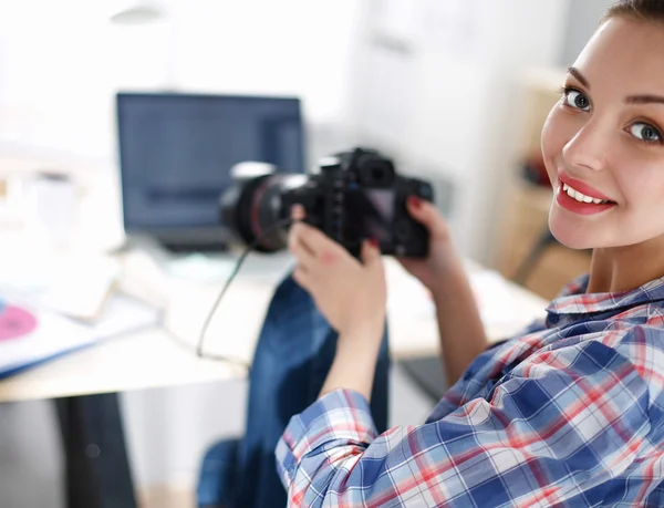 Masada dizüstü bilgisayarla oturan kadın fotoğrafçı.