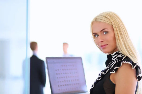 Ung affärskvinna med bärbar dator, stående på kontoret — Stockfoto