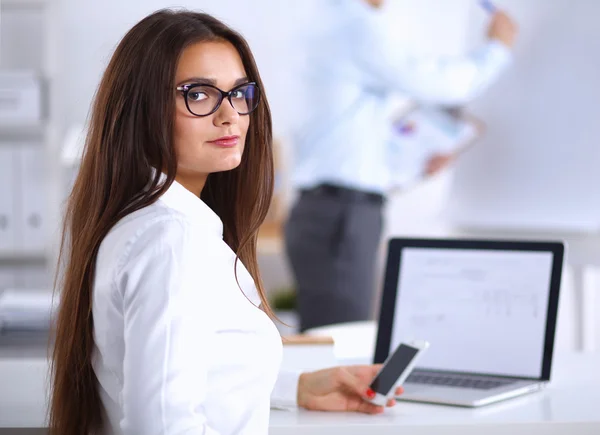 Empresária atraente sentada na mesa no escritório — Fotografia de Stock