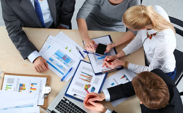 İş adamları iş toplantısında, ofiste oturup tartışıyorlar.