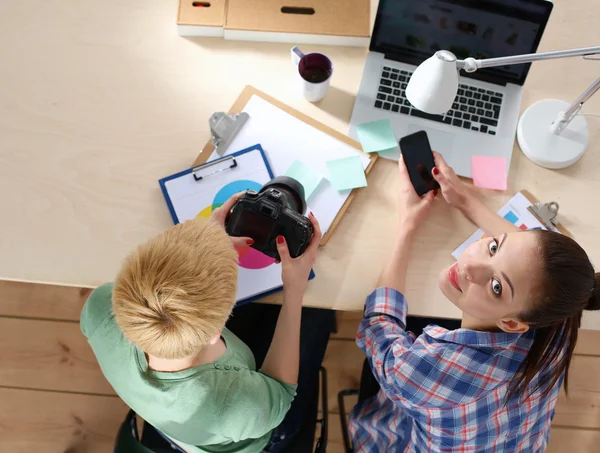 Female photographer sitting on the desk with laptop — Stock Photo, Image