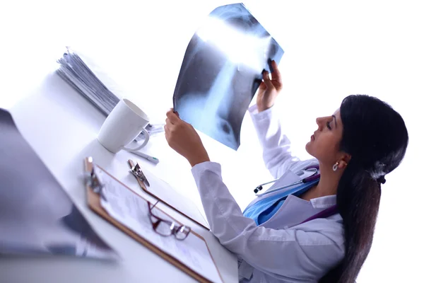 Doctora joven estudiando imagen de rayos X, sentada en el escritorio — Foto de Stock