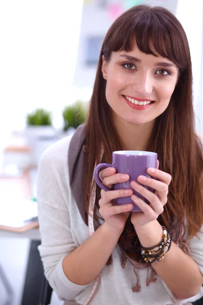 Moderno diseñador de moda joven con taza en el estudio — Foto de Stock