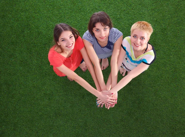 People joining their hands  standing on green grass — Stock Photo, Image