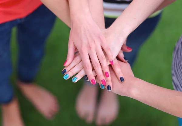 People joining their hands  on green grass — Stock Photo, Image