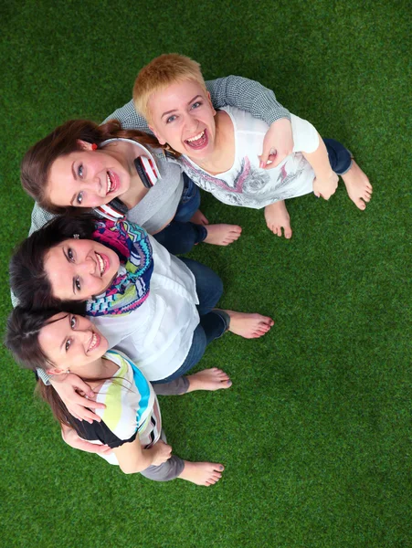 Four young women standing on green grass — Stock Photo, Image