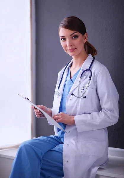 Молодой врач или медик с планшетом и стетоскопом изолированы на сером фоне — стоковое фото