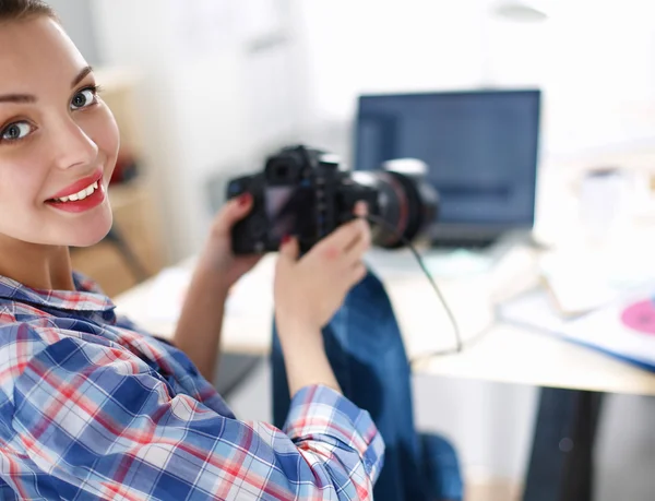 Kvinnlig fotograf sitter på skrivbordet med bärbar dator — Stockfoto