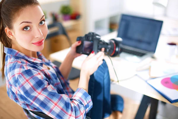 Femme photographe assise sur le bureau avec ordinateur portable — Photo