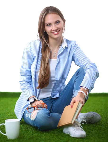 Jonge vrouw zitten met boek op gras — Stockfoto