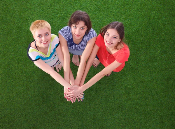 Lidé spojení jejich ruce, stojící na zelené trávě — Stock fotografie