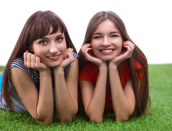 Две молодые женщины лежат на зеленой траве — стоковое фото