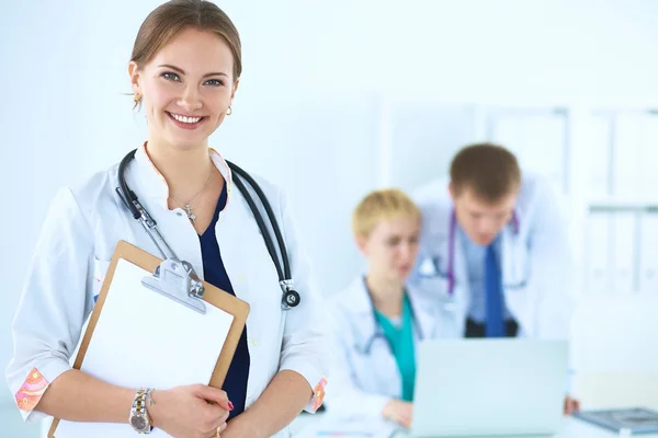 Attractive female doctor  with folder in front of medical group Stock Photo