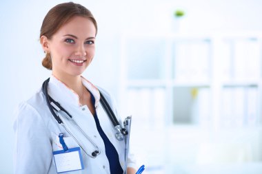 Kadın doktor hastanede steteskopla dikiliyor. 