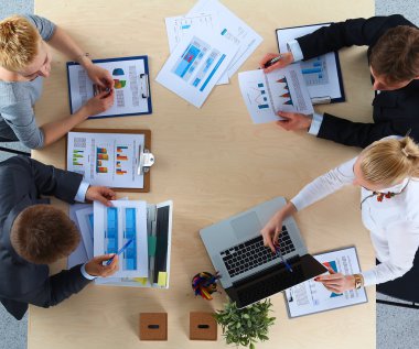 İş adamları iş toplantısında, ofiste oturup tartışıyorlar.