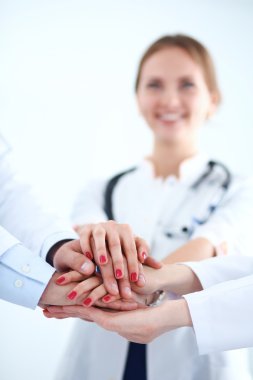 Doktorlar ve hemşireler tıbbi bir ekipte el ele tutuşuyorlar. 