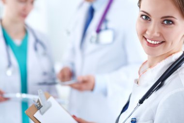 Masada oturan gülümseyen güzel genç bayan doktor.