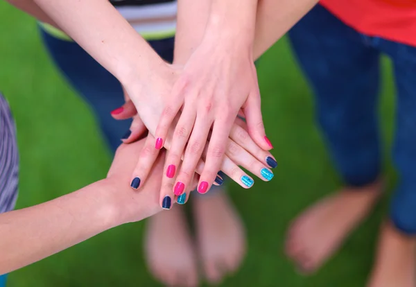 Yeşil çimenlerin üzerinde ellerini katılmak insanlar