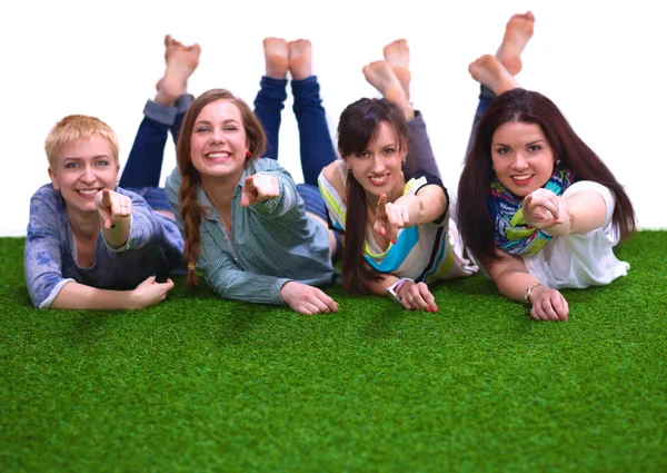 Four young women lying on green grass — Stock Photo, Image