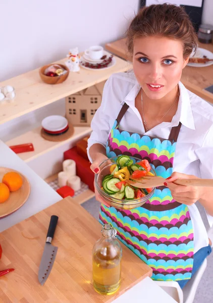 Ung kvinna äter färsk sallad i modernt kök — Stockfoto