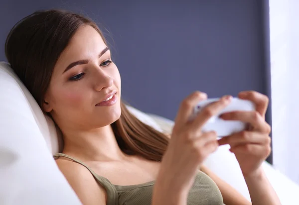 Mooie vrouw in haar woonkamer liggend op de bank verzenden puinhoop — Stockfoto