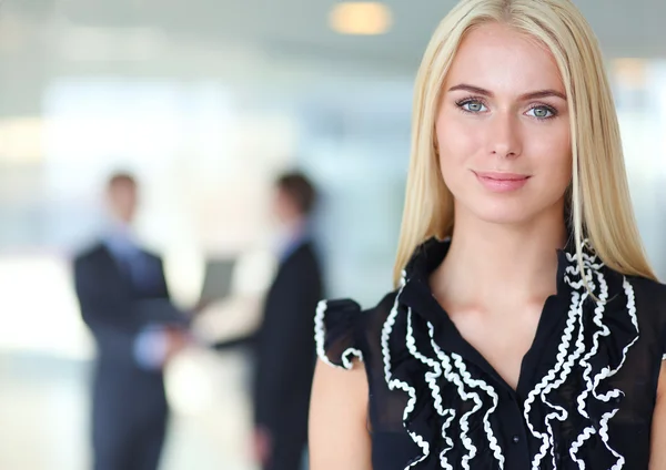 Business woman standing in foreground  in office — Stock Photo, Image
